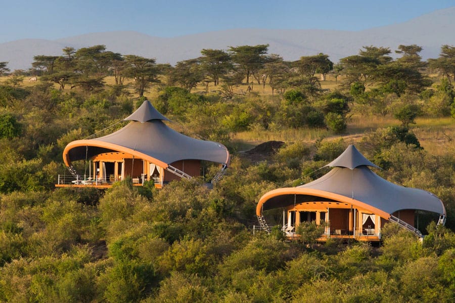 Eco-friendly glamping site with solar panels, rainwater collection barrels, and native landscaping